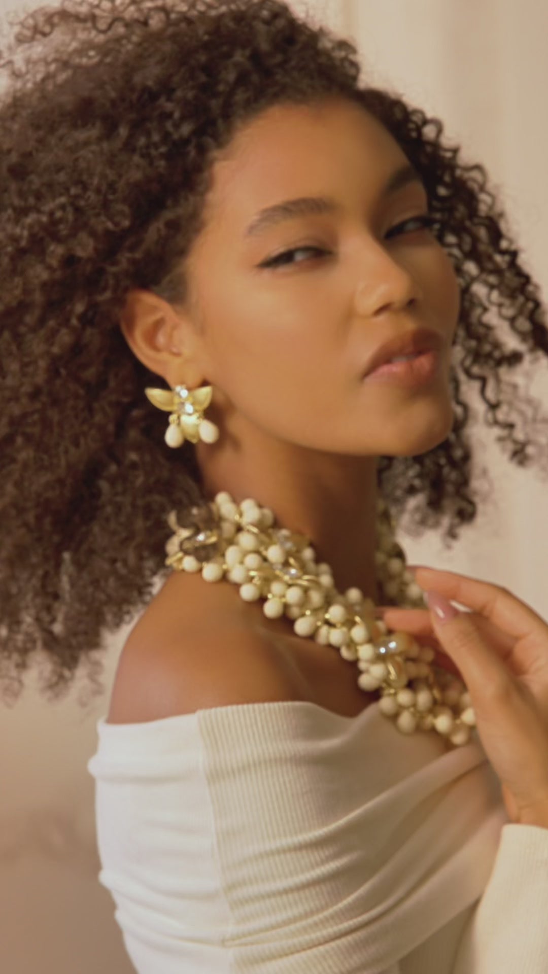 Gold floral dangle earrings with crystal centers and soft ivory drop accents in a honey toned elegant design.