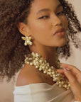 Gold floral dangle earrings with crystal centers and soft ivory drop accents in a honey toned elegant design.