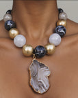 Natural stone statement necklace featuring a gray and black agate slice edged in a Gold tone finish.