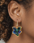 Close up of Valerie Miss Beasley earrings showcasing green, blue and purple faceted crystals with sparkling borders.