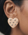Close up of Lovebug 18K Stud showing a dimensional cream heart with seven sparkling crystal accents.