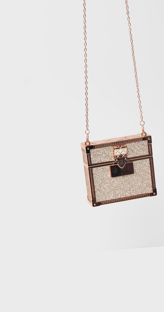 Luxury red lipstick trio with three velvety matte red shades and glittering gold clutch case with chain strap