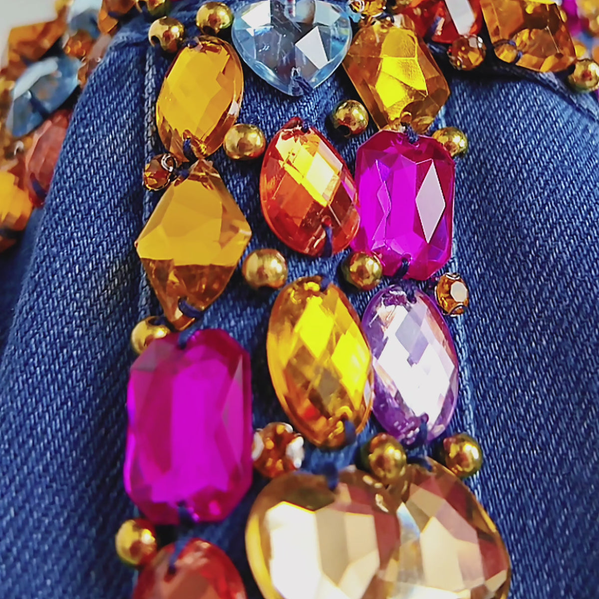 Close up of Gemma Crystal Jogger Jacket featuring multicolor faceted stones across the denim yoke and sleeves.