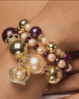  Sassy Jones Reign three-piece bracelet stack featuring champagne pearls, purple beads and 18K gold plated details.