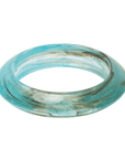 Aqua blue marbled resin bangle bracelet with ivory and taupe swirls in a tapered elongated silhouette on a white background.